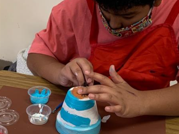Student painting blue and white flower pot